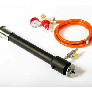 May include: A black metal torch with a silver nozzle and a red pressure gauge. An orange hose and brass fittings are connected to the torch. The torch is designed for industrial or professional use.