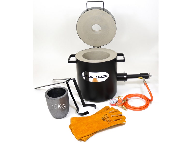 Puede incluir: Un horno de fusi&oacute;n de metal negro con un crisol de cer&aacute;mica gris, una pinza para crisol, un par de guantes de soldadura de cuero, un regulador de gas y un crisol de 10 kg. El horno tiene una etiqueta plateada que dice "Devil-Forge".