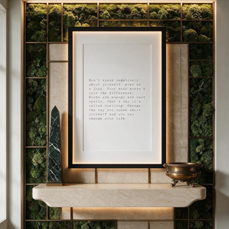 Framed typographic self talk print on a preserved moss and bronze grid wall above a pale travertine console.
