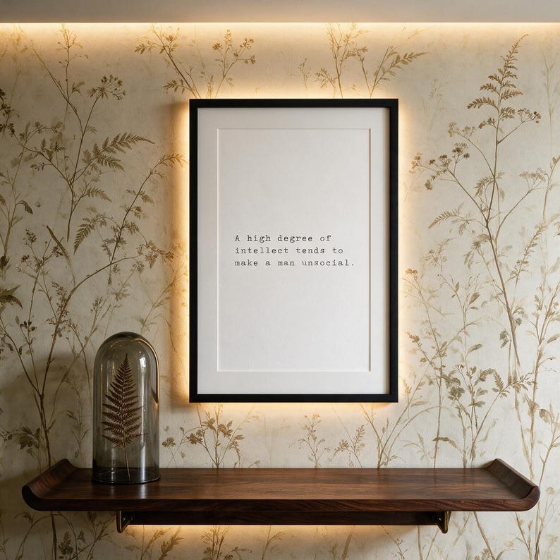 Framed typographic introvert print on a hand-painted botanical wall above a dark walnut console with glass cloche.