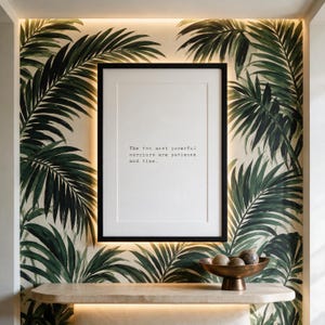 Framed typographic stoic print on a hand-painted palmette mural wall above a pale limestone console.