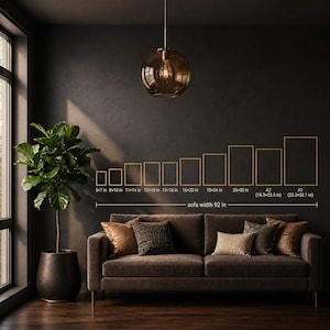 May include: A dark brown sofa with decorative cushions, a potted fiddle leaf fig plant, and a pendant light. A wall chart displays various frame sizes from 12.7x17.8 cm to 59.4x84.1 cm, with a reference line indicating a sofa width of 233.7 cm for scale.