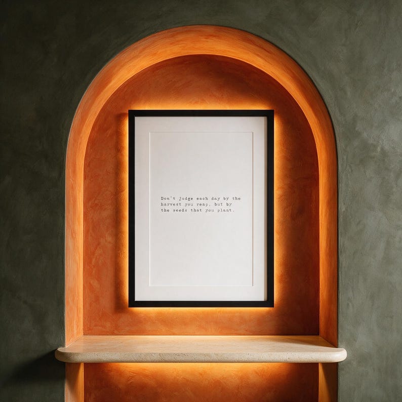 Framed typographic growth print within a backlit persimmon plaster arch.
