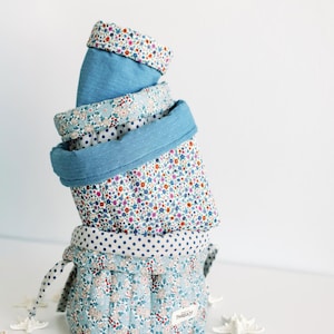 May include: A set of three ceramic mugs with a speckled, matte finish. The mugs are in shades of cream, light gray, and dark gray. Each mug has a simple, minimalist design and a rounded handle.