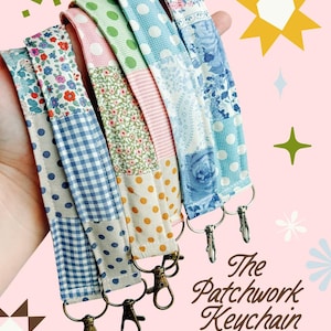 May include: A set of fabric wristlet keychains featuring various patchwork patterns including blue gingham, green polka dots, floral prints, and paisley designs. Each strap is finished with a metal swivel lobster clasp for attaching keys.