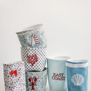 May include: A set of three ceramic mugs with a speckled, matte finish in cream, light grey, and dark grey. Each mug has a simple, modern design and a rounded handle.