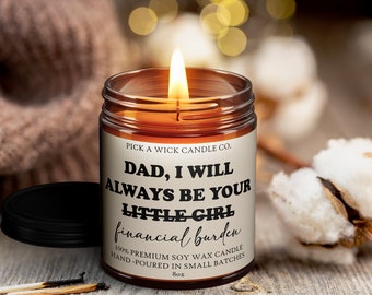 May include: A lit soy wax candle in a glass jar with a black lid. The label reads "DAD, I WILL ALWAYS BE YOUR LITTLE GIRL financial burden." The candle is 8oz.