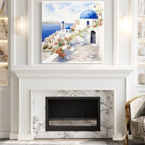 a living room with a fireplace, a bookshelf, and a framed picture of a scenic view of a Greek island with a blue dome and white buildings.