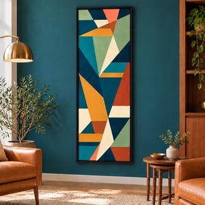 May include: A tall, rectangular wall art piece featuring a geometric composition of triangles and polygons in shades of teal, mustard yellow, terracotta orange, cream, and dark blue, enclosed within a thin black frame.