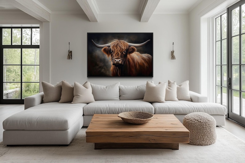 a large, comfortable living room with a large, white sectional sofa, a wooden coffee table, and a framed painting of a horned animal on the wall.