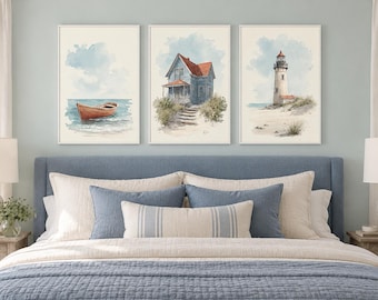 May include: A set of three framed watercolor prints displayed above a bed. The left print shows a red boat on water, the center print depicts a blue house with a red roof, and the right print features a lighthouse on a sandy beach.