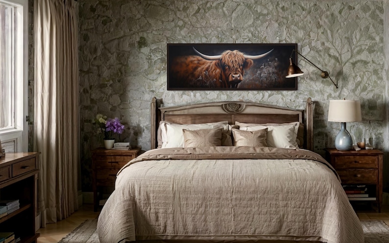 a bedroom with a large bed, a framed painting of a horned animal, and a lamp on a nightstand.