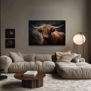 a cozy living room with a large, comfortable couch and a coffee table. Above the couch, there is a framed painting of a cow with long horns, adding a unique touch to the room's decor. The room also features a bookshelf filled with books, creating a warm and inviting atmosphere.