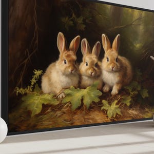 three rabbits sitting together in a forest setting, surrounded by leaves and branches.