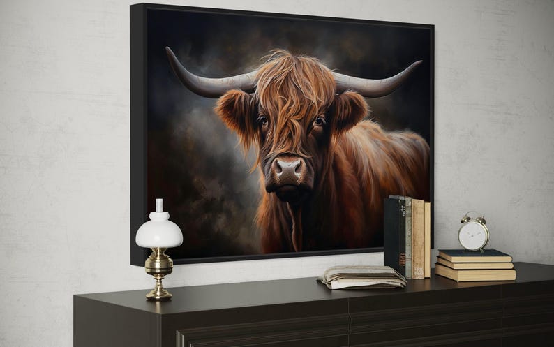 a large framed painting of a brown cow with long horns, displayed on a wall above a wooden dresser.