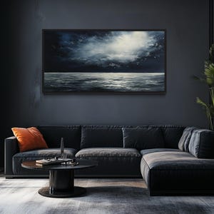 a modern living room with a large black sectional sofa, a round coffee table, and a large window overlooking a dark sky. A painting of a stormy sea is displayed on the wall above the sofa.