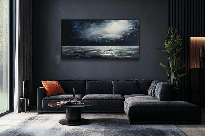 a modern living room with a large black sectional sofa, a round coffee table, and a large window overlooking a dark sky. A painting of a stormy sea is displayed on the wall above the sofa.