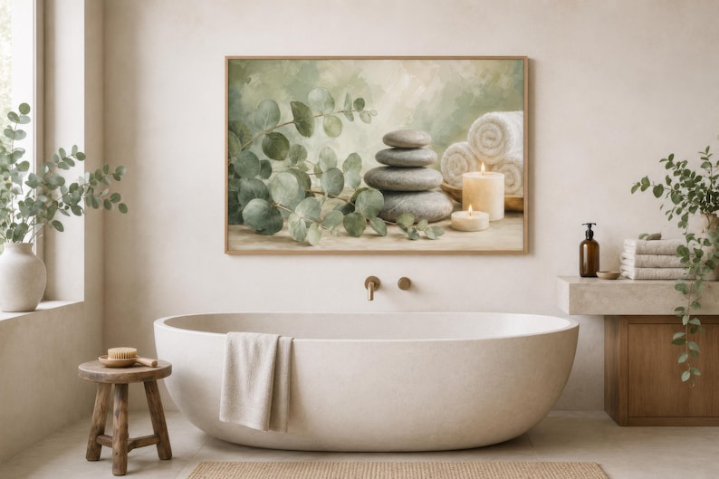 May include: A rectangular wall art print featuring a stack of smooth grey stones, green eucalyptus branches, two lit cream-coloured candles, and rolled white towels against a soft, muted green and beige background, displayed in a wooden frame.
