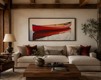 Op de afbeelding: Een rechthoekig wandkunstwerk met een felrode kano die op kalm water drijft, ingelijst in donker hout. Het schilderij vangt de reflectie van de kano op het wateroppervlak, wat een symmetrisch visueel effect creëert.