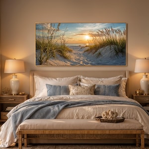 May include: A rectangular landscape wall art print featuring a sunset over a sandy beach with tall dune grasses. The scene displays a golden sun low on the horizon, casting light over white sand dunes and coastal vegetation under a blue sky.