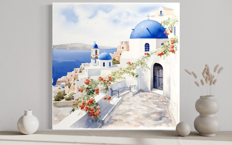 The image is a watercolor painting depicting a picturesque view of a Greek island with white buildings, blue domes, and a winding path leading to the water.