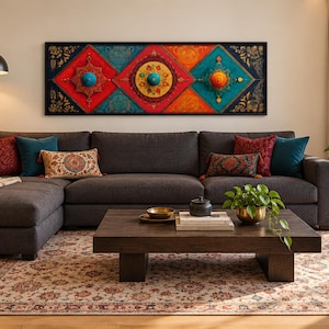 Puede incluir: Una pieza de arte mural rectangular larga con tres paneles en forma de diamante en rojo, naranja y turquesa, con detalles de filigrana dorada y esferas centrales elevadas, montada sobre un sof&aacute; seccional gris oscuro con cojines decorativos.