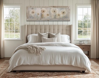 Puede incluir: Un dormitorio de tonos neutros con una cama tapizada beige, ropa de cama blanca y cojines decorativos. Una obra de arte enmarcada de dientes de león cuelga sobre la cama. La habitación incluye cortinas y una alfombra estampada. La cama mide unos 150 cm de ancho.