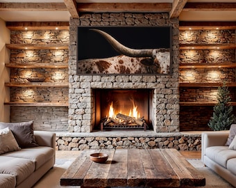 May include: A cozy living room with a stone fireplace and built-in shelves. A large framed image of a longhorn is above the fireplace. The room features a wooden coffee table, two sofas, and a small Christmas tree.