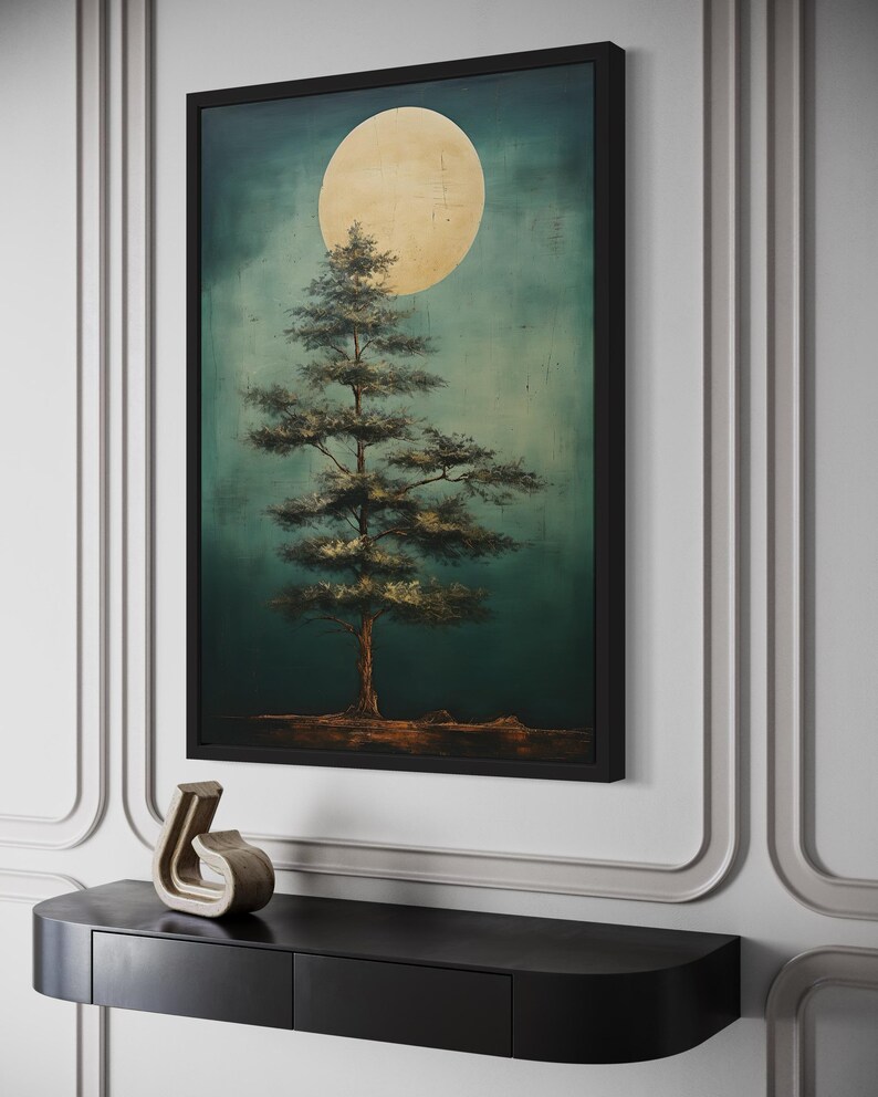 a large framed painting of a tree with a large yellow moon in the background, hanging on a wall above a black shelf.