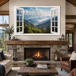 May include: A rectangular wall art print featuring an open white window frame looking out onto a scenic landscape of blue-toned mountain ranges, green pine forests, and a bright sky with white clouds, displayed above a stone fireplace.