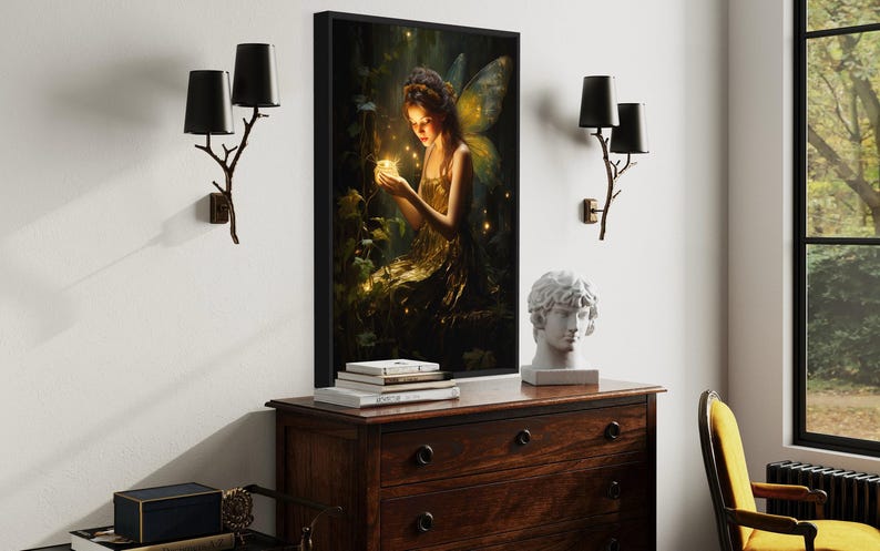 a large painting of a fairy with a glowing lantern in her hand, displayed on a wall above a wooden dresser. The dresser has a white bust and a stack of books on top. The room has a window with trees visible outside, and there are two black lamps on the wall.