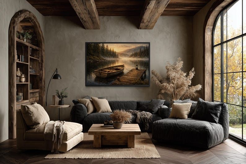 May include: A cozy living room with a framed landscape painting of a lake and boat. The room features a dark gray sofa, a wooden coffee table, and a beige armchair. The room is decorated with neutral tones and natural elements.