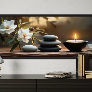 A framed painting depicting a serene still life scene with white flowers, a lit candle, and a stack of books on a shelf.