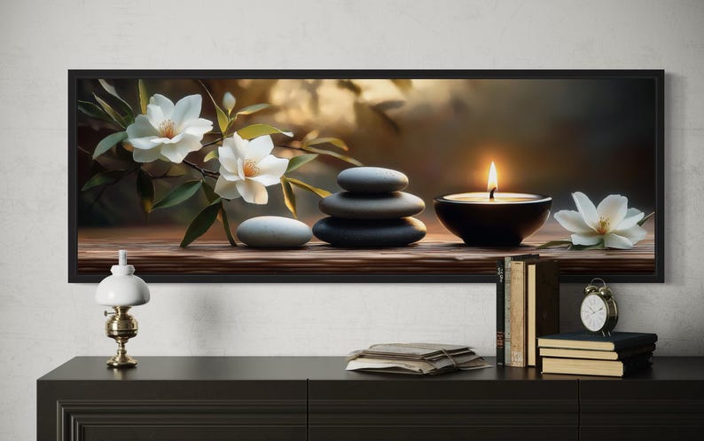 A framed painting depicting a serene still life scene with white flowers, a lit candle, and a stack of books on a shelf.
