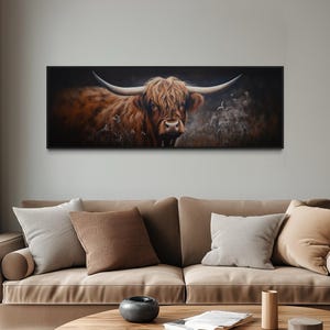a large painting of a horned animal, possibly a yak or a bull, displayed on the wall above a beige sofa in a living room setting.