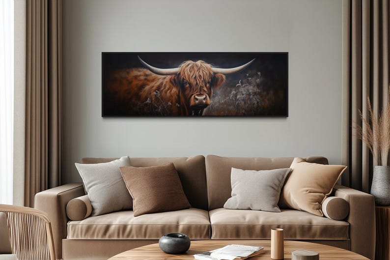 a large painting of a horned animal, possibly a yak or a bull, displayed on the wall above a beige sofa in a living room setting.
