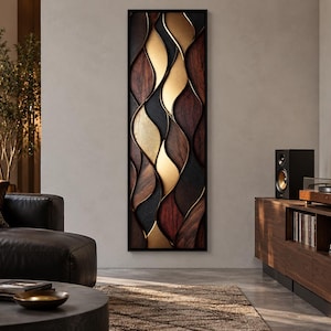 May include: A tall, rectangular wall art piece featuring a vertical arrangement of layered, undulating shapes in dark wood, black, and metallic gold finishes, all enclosed within a thin, black frame that creates a three-dimensional effect.