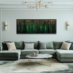 Könnte beinhalten: Ein rechteckiges abstraktes Kunstwerk mit schwarzem Rahmen hängt über einem hellgrünen Ecksofa. Das Kunstwerk zeigt ein grünes und goldenes Design mit vertikalen Linien und funkelnden Akzenten. Der Raum hat eine moderne Ästhetik.