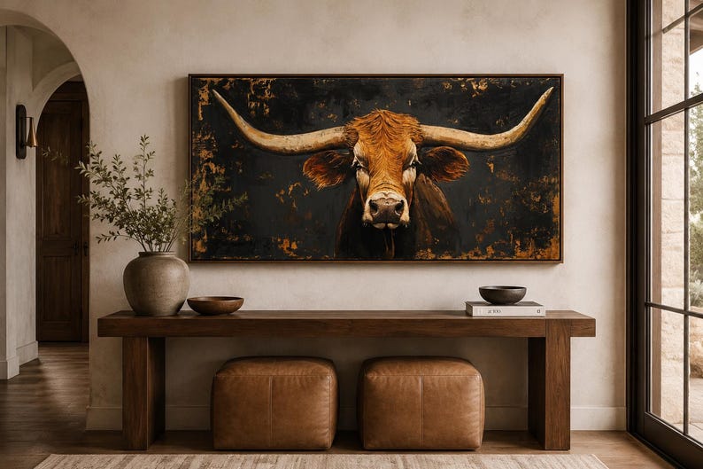 May include: A rectangular wall art piece featuring a detailed portrait of a longhorn steer with prominent horns, set against a dark, textured background with gold accents. The artwork is framed in a thin, dark wood border and displayed horizontally.
