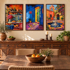 May include: Three rectangular framed wall art prints featuring vibrant, colourful scenes of a kitchen interior, a sunlit doorway, and a courtyard fountain. The artwork displays rich tones of orange, blue, and yellow, presented in dark wood frames.