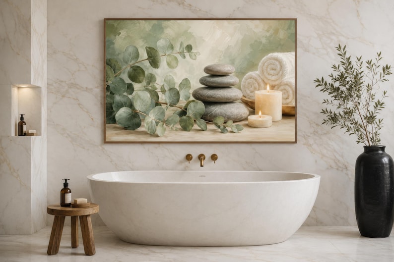 May include: A rectangular wall art print featuring a stack of four smooth grey stones, green eucalyptus branches, two white rolled towels, and two lit pillar candles. The artwork is displayed in a bathroom above a white oval freestanding bathtub.