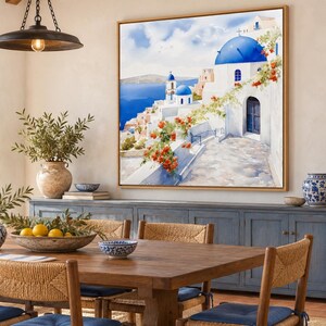 May include: A square framed wall art print depicting a Greek island landscape with white buildings, blue domes, and vibrant orange flowers. The scene features a stone pathway leading toward the sea under a bright blue sky with soft clouds.