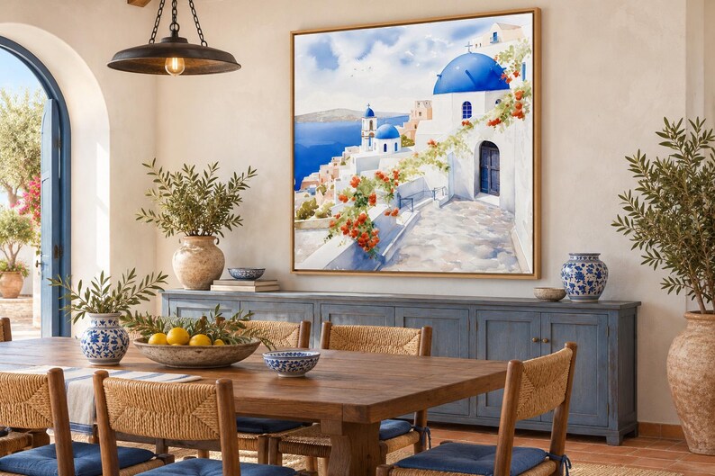 May include: A square framed wall art print depicting a Greek island landscape with white buildings, blue domes, and vibrant orange flowers. The scene features a stone pathway leading toward the sea under a bright blue sky with soft clouds.