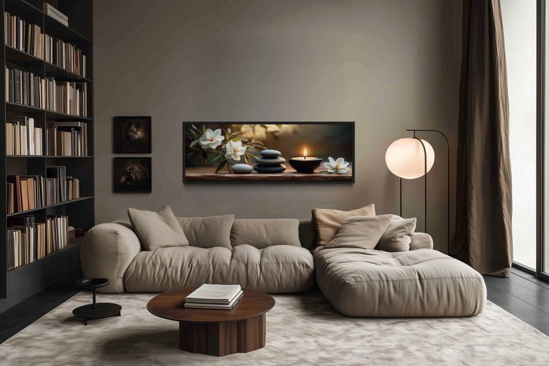 a cozy living room with a large bookshelf filled with books, a comfortable sofa, a coffee table, and a painting of flowers on the wall.
