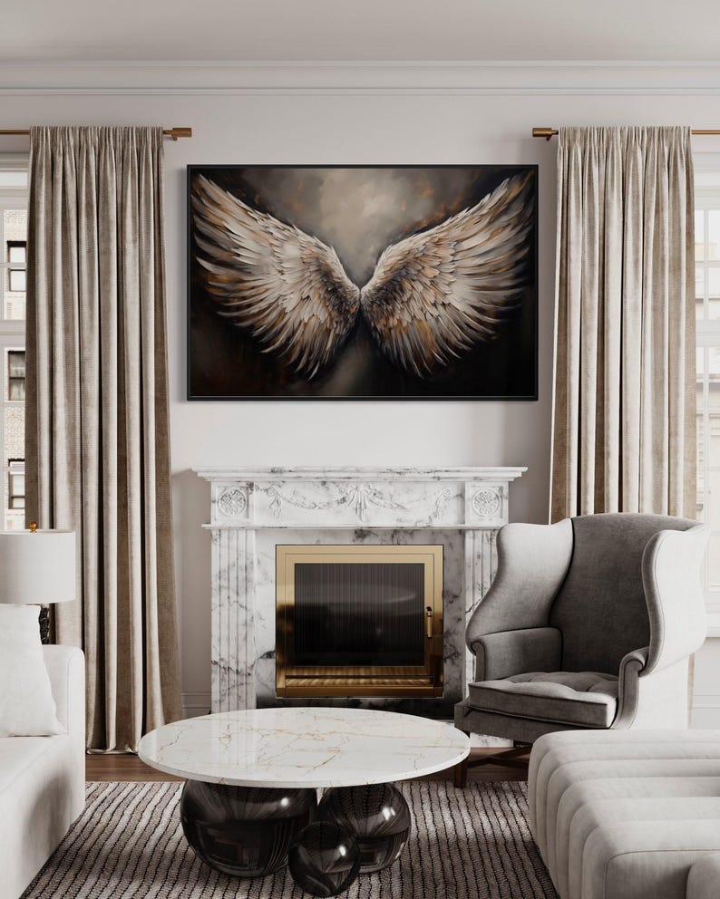 a luxurious living room with a large painting of a pair of angelic wings hanging above a fireplace. The room is furnished with a gray armchair, a white sofa, and a round marble coffee table. The overall decor and furnishings create a sophisticated and elegant atmosphere.