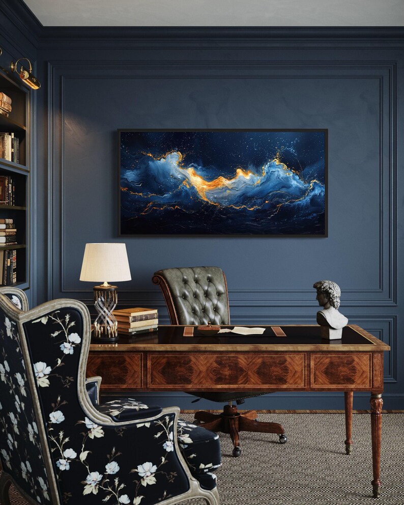 a well-decorated office space with a large abstract painting of a swirling ocean scene on the wall, complemented by a wooden desk, a tufted leather chair, and a lamp.