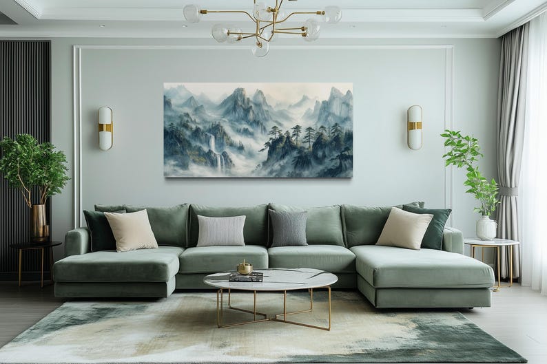 a modern living room with a large green sectional sofa, a round coffee table, and a painting of a mountainous landscape hanging on the wall.