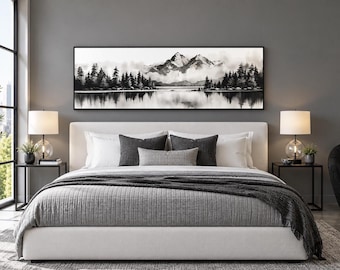 May include: A panoramic black and white landscape wall art print featuring a mountain range partially obscured by mist, with a dense forest of pine trees in the foreground and their reflection visible in the calm water below the peaks.