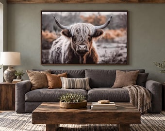 May include: A large rectangular wall art print featuring a close-up portrait of a Highland cow with long, shaggy fur and curved horns. The cow is set against a blurred, muted landscape background with earthy brown and grey tones.