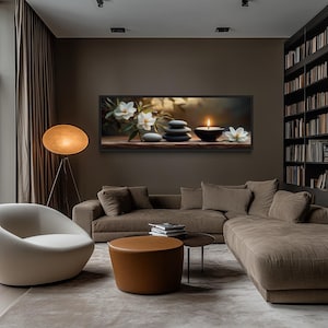 a modern living room with a large window overlooking trees, a bookshelf filled with books, and a comfortable couch and armchair arrangement.